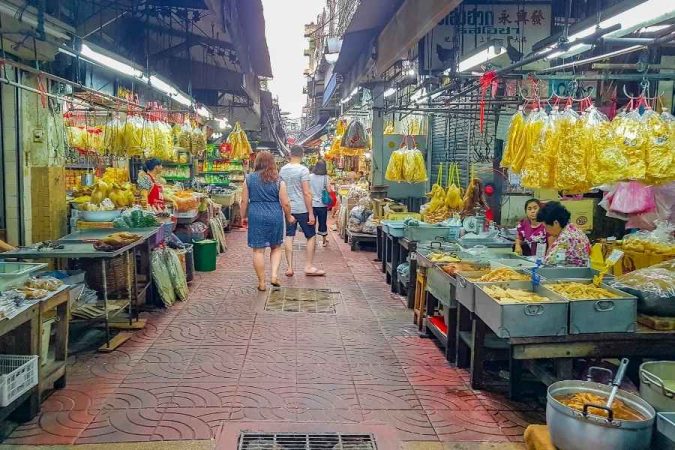 Des visiteurs se promènent dans un marché couvert animé en Asie, une expérience authentique du tourisme local.