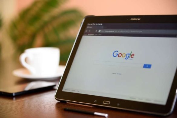 Une tablette tactile Samsung affiche la page de recherche Google sur une table de bureau.