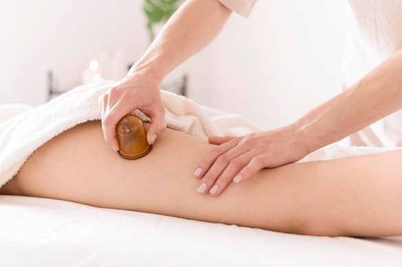 Application d’une ventouse de massage en verre sur la cuisse lors d’un soin anti-cellulite.